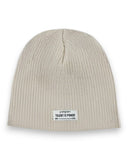 Zestaw czapka beanie i komin dla chłopca marki PanPan 35 to beżowy zestaw z prążkowanej dzianiny bawełnianej z czapką z prostokątną białą naszywką z napisem "panpan TALENT IS POWER MR. CBD" w kolorze czarnym. Idealny na wiosnę!.