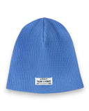 PanPan 35 Zestaw czapka beanie i komin dla chłopca to niebieska, prążkowana bawełniana czapka wiosenna z małą białą naszywką z przodu z napisem "pampuni TALENT IS POWER 1985 1995" w kolorze czarnym.