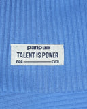 Biała materiałowa metka na niebieskim prążkowanym materiale z zestawu PanPan 35 czapka beanie i komin dla chłopca brzmi: panpan TALENT IS POWER FOR ___ EVER, z pustą linią pomiędzy FOR i EVER.
