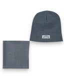 Zestaw czapka beanie i komin dla chłopca - bawełna, prążek, wiosna marki PanPan 35 jest w kolorze szarym. Prążkowana bawełniana czapka ma małą białą etykietę TALENT IS POWER z dodatkowym tekstem pod spodem.