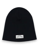 Zestaw czapka beanie i komin dla chłopca marki PanPan 35 to czarna, prążkowana bawełniana czapka dla dzieci z białą naszywką z napisem "panpan TALENT IS POWER" z przodu na białym tle.