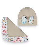 PanPan 35 "Zestaw czapka z kokardą i chusta dla dziewczynki" zawiera beżową bawełnianą czapkę z kwiatową kokardą i pasujący do niej falbaniasty koc, oba z wiosennym kwiatowym nadrukiem, prezentowane na białym tle.