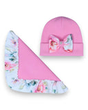 PanPan 35 Zestaw czapka z kokardą i chusta dla dziewczynki - różowy bawełniany zestaw z czapką z kokardą w kwiatowy print i pasującą chustą, prezentowany jest na białym tle. Idealny na wiosnę!.