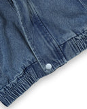Zbliżenie dolnej części kurtki jeansowej dziecięcej unisex PanPan 35 - wiosenna, przejściowa, pokazująca dwie kieszenie, elastyczny pas i srebrny guzik zatrzaskowy na białym tle.