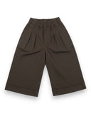 PanPan 35 Wiosenne spodnie z szeroką nogawką z mankietami dla dziewczynek to ciemnobrązowe, w 100% bawełniane spodnie z elastycznym pasem, zakładkami z przodu i bocznymi kieszeniami, pokazane płasko na białym tle.