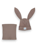 PanPan 35 Zestaw czapka z uszami królika i komin - bawełna, prążek zawiera brązową prążkowaną czapkę z długimi uszami królika i naszywką z twarzą kota oraz pasujący ocieplacz na szyję, tworząc uroczy zestaw dziecięcy na białym tle.