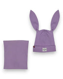 Zestaw czapka z uszami królika i komin - bawełna, prążek marki PanPan 35 to lawendowa czapka w prążki z wysokimi uszami królika i naszywką na twarz oraz dopasowanym ocieplaczem na szyję - idealna lekka czapka bawełniana dla dzieci, pokazana na białym tle.